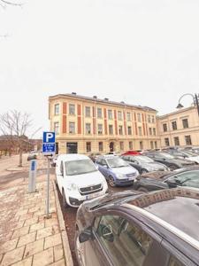 un estacionamiento con autos estacionados frente a un edificio en Rentalux Apartments at Nytorget, en Sundsvall