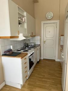 Il comprend une petite cuisine équipée d'une cuisinière et d'un évier. dans l'établissement Rentalux Apartments at Nytorget, à Sundsvall