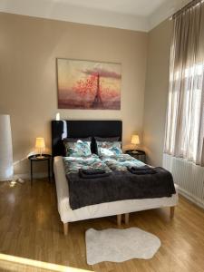 a bedroom with a bed and two tables and two lamps at Rentalux Apartments at Nytorget in Sundsvall