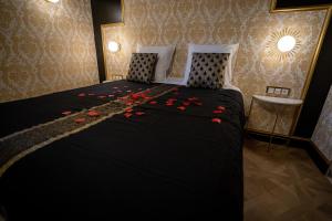 Un dormitorio con una cama con rosas rojas. en Appartement d'exception avec Jacuzzi en Villefranche-sur-Saône