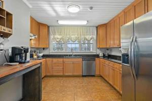 a kitchen with wooden cabinets and a stainless steel refrigerator at Cypress Grove - Dog River in Mobile