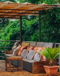 a couch sitting under an umbrella on a deck at Edelwyss-Inn in Morogoro