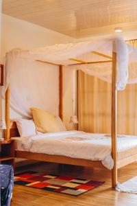 a bedroom with a canopy bed and a rug at Edelwyss-Inn in Morogoro