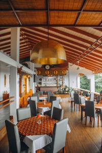 un restaurant avec des tables et des chaises et un grand plafond dans l'établissement Edelwyss-Inn, à Morogoro