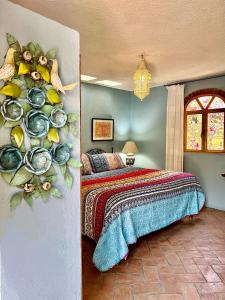 a bedroom with a bed with a painting on the wall at Boutique Hotel Casa Camellia in San Miguel de Allende