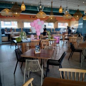 een restaurant met tafels en stoelen en roze ballonnen bij The Luxe Marvelous Apartment in Pretoria