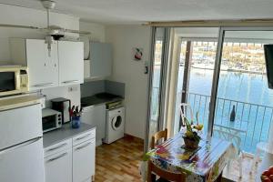eine Küche mit einem Tisch und Blick auf das Wasser in der Unterkunft Appartement ensoleillé au Cap d'Agde in Cap d'Agde