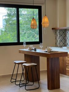 uma cozinha com um balcão de madeira com dois bancos em New Studio p/2, jacuzzi, alberca, roof top em Tulum