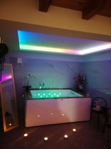 a large tub in a room with a purple lighting at A Trecastagni - Etna Home in Trecastagni