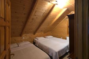 a bedroom with two beds in a wooden attic at Brvnara Bjelasica in Kolašin