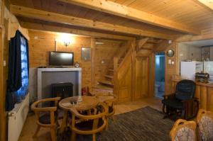 ein Zimmer mit einem Tisch und einem Kamin in einer Blockhütte in der Unterkunft Brvnara Bjelasica in Kolašin