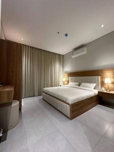 een slaapkamer met een groot bed en een badkamer bij Almajdiah Village Luxury Self-entry Al Malqa in Riyad