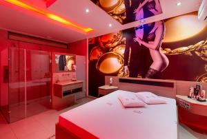 ein rotes Zimmer mit einem Bett und einem Bad in der Unterkunft Motel Fashion ABC 2 in Santo André