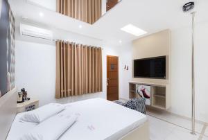 um quarto branco com uma cama e uma televisão em Motel Fashion ABC 2 em Santo André