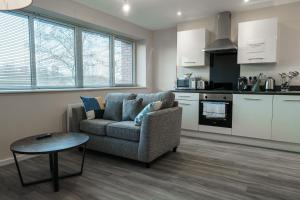 a living room with a couch and a table at Modern Manchester Apartment, Free Parking For Two, Smart TVs, Central Location in Manchester