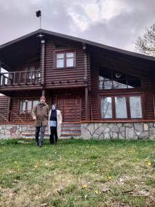 two people standing in front of a log house at Chalet's lake_Bolu Abant _log house in Piroğlu