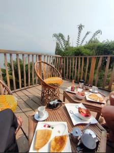 a table with plates of food on a deck at Ruhondo Beach Resort in Ruhengeri
