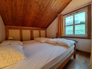 Bett in einem Zimmer mit Holzdecke in der Unterkunft Les Chalets de Flaine Hameau - maeva Home - Chalet 4 Pièces 8 Personnes - Sél 91 in Flaine