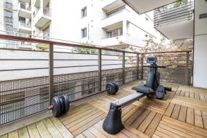 - une salle de sport avec des haltères sur le balcon d'un bâtiment dans l'établissement Villa Le Saint-Charles, à Paris
