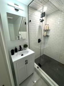 uma casa de banho com um lavatório e um chuveiro com um espelho. em Home Away From Home in Lowell em Lowell