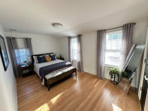 1 dormitorio con 1 cama, suelo de madera y ventanas en Home Away From Home in Lowell, en Lowell