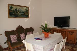 a dining room with a table and chairs and a television at App. Biancavilla Catania I in Biancavilla
