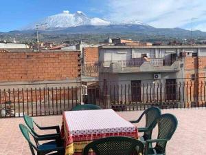 a table and chairs on a balcony with a snow covered mountain at App. Biancavilla Catania I in Biancavilla