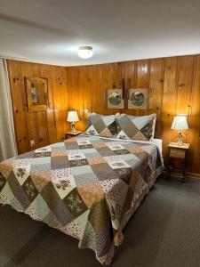a bedroom with a bed with a quilt on it at The Evening Shade River Lodge and Cabins in Chimney Rock