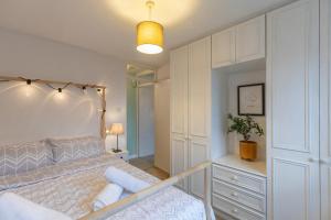 1 dormitorio blanco con 1 cama grande y espejo en Chic Flat in Woolston: Nr Southampton City Centre en Southampton