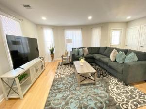 sala de estar con sofá y TV en Modern and all new 3BR near UMASS en Lowell