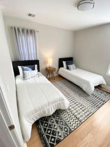 2 camas en una habitación con alfombra en Modern and all new 3BR near UMASS en Lowell