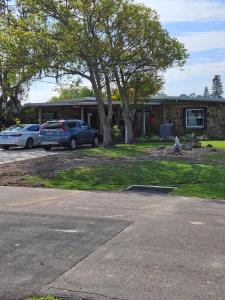 dos autos estacionados frente a una casa en WaterFront Mid Century Cottage - Close to beach - 2 BR 3 BA en Ruskin