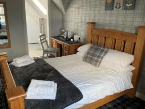 a bedroom with a bed and a desk at Glenshee Guest House in Golspie