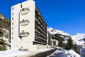 un edificio blanco con un coche aparcado delante de él en Résidence Andromède - maeva Home - Studio 4 personnes Confort 16, en Flaine