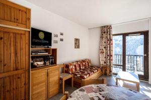 een woonkamer met een bank en een televisie bij Résidence Andromède - maeva Home - Studio 4 personnes Confort 16 in Flaine