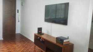 a flat screen tv hanging on a white wall at Apartamento Vista Farol da Barra com 2 Quartos in Salvador