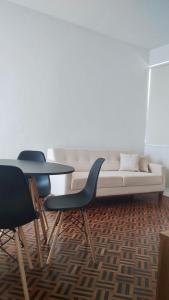 a living room with a couch and two chairs at Apartamento Vista Farol da Barra com 2 Quartos in Salvador