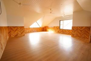 Habitación grande y vacía con suelo de madera y ventana. en Zaabeel Villa Kashmir, en Srinagar