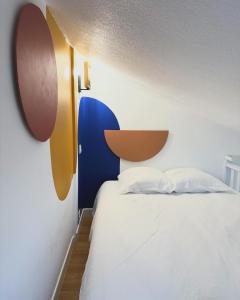 um quarto com uma cama branca e uma cabeceira em madeira em Maisonnette Au bord du lac Marin Port Leucate em Leucate