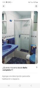 a bathroom with a shower and a blue toilet at Hermosa Casa en el Polo in Lima