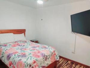 1 dormitorio con 1 cama y TV de pantalla plana en Hermosa Casa en el Polo, en Lima