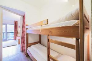 Ce dortoir comprend 2 lits superposés et une fenêtre. dans l'établissement Résidence Andromède - maeva Home - Studio 4 Personnes - Confort 51, à Flaine