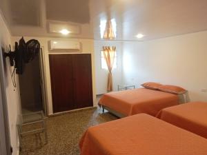- une chambre d'hôtel avec 2 lits et une porte dans l'établissement HOTEL GANADERO, à La Dorada