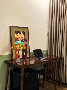 a desk with a laptop and a picture of a couple at A Little Saigon in Ho Chi Minh City