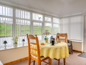 a dining room with a table and chairs and windows at 1 Bed in Newton Stewart DF198 in Newton Stewart