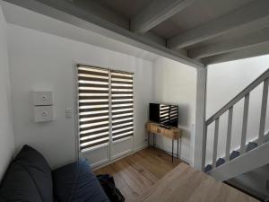 a living room with a window and a television at Maisonnette Au bord du lac Marin Port Leucate in Leucate