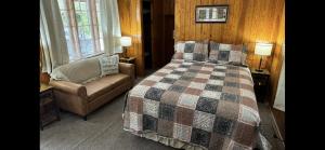 - une chambre avec un lit, un canapé et une chaise dans l'établissement The Evening Shade River Lodge and Cabins, à Chimney Rock