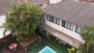 an overhead view of a building with a pool and palm trees at Oceanic Hostel in Balneário Camboriú