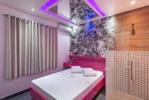 Habitación rosa con cama y ducha en Motel Fashion ABC 4, en Santo André