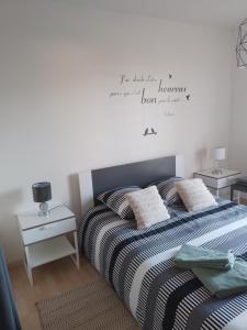 a bedroom with a bed with a quote on the wall at Chambre agréable au calme in Saint-Hilaire-Petitville